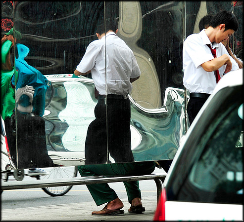 Legs merger of taxi driver and seated man on Le Tan Ton Street